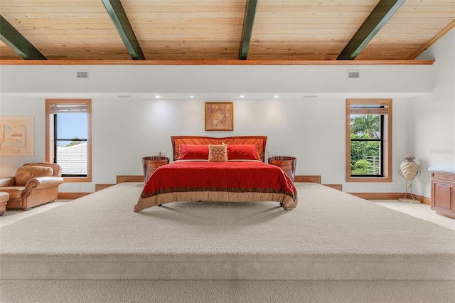 bedroom featuring baseboards, visible vents, and beamed ceiling