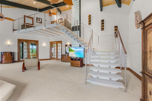 stairway with baseboards, carpet flooring, french doors, high vaulted ceiling, and beam ceiling