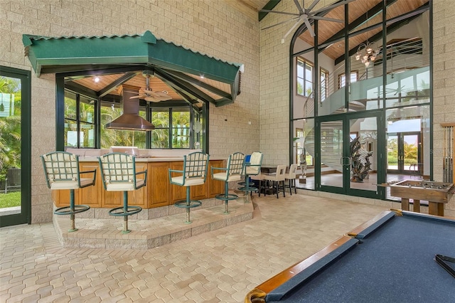 interior space featuring a bar, french doors, and a ceiling fan