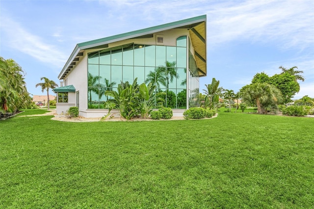 view of side of home featuring a yard and stucco siding