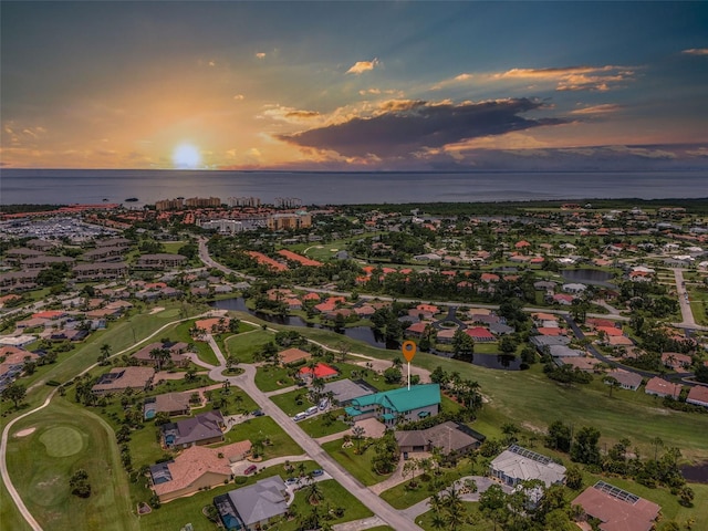 aerial view at dusk with a residential view and a water view