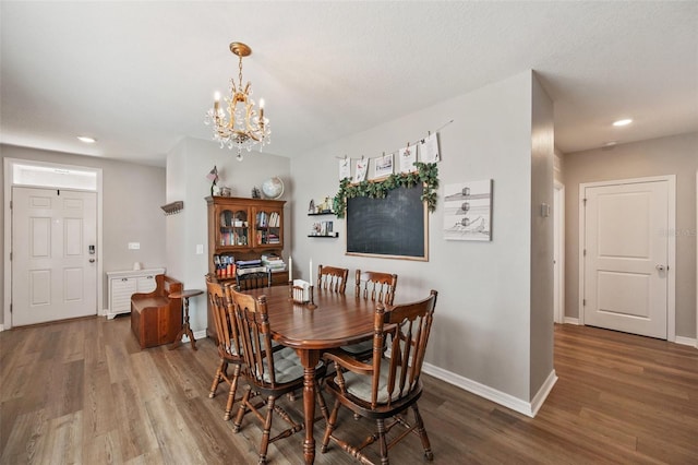 dining space with an inviting chandelier, baseboards, wood finished floors, and recessed lighting