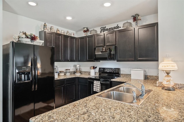 kitchen with black appliances, dark brown cabinets, a sink, and recessed lighting