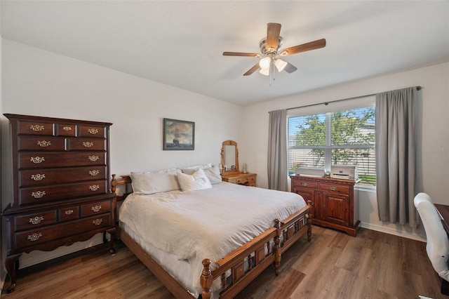 bedroom with ceiling fan, baseboards, and wood finished floors