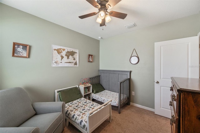 bedroom with a ceiling fan, visible vents, light carpet, and baseboards