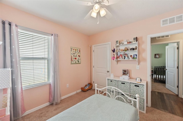 bedroom featuring light colored carpet, visible vents, ceiling fan, and baseboards