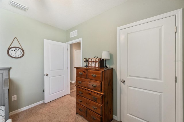 bedroom with baseboards, visible vents, and light colored carpet