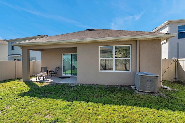 back of house featuring a patio, central AC unit, fence, a lawn, and stucco siding