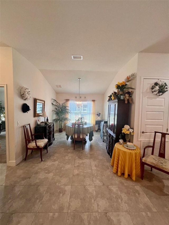 dining area with lofted ceiling, visible vents, and a chandelier