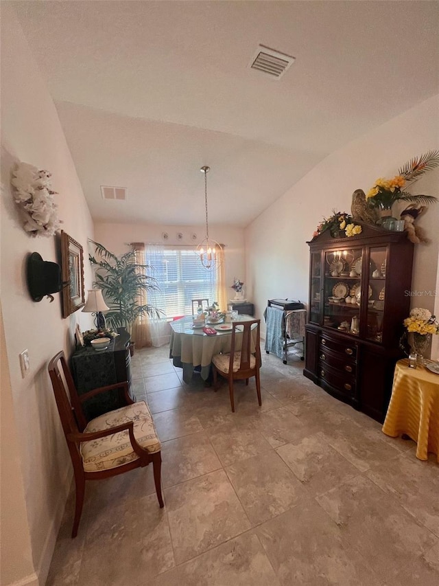 dining space with vaulted ceiling, visible vents, and an inviting chandelier