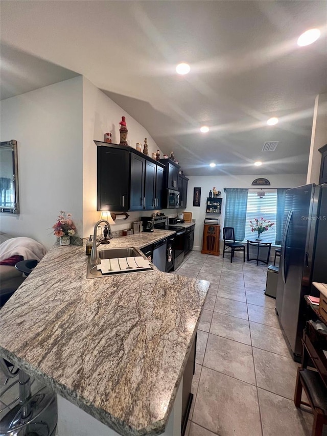 kitchen with light tile patterned floors, stainless steel appliances, visible vents, a sink, and a peninsula