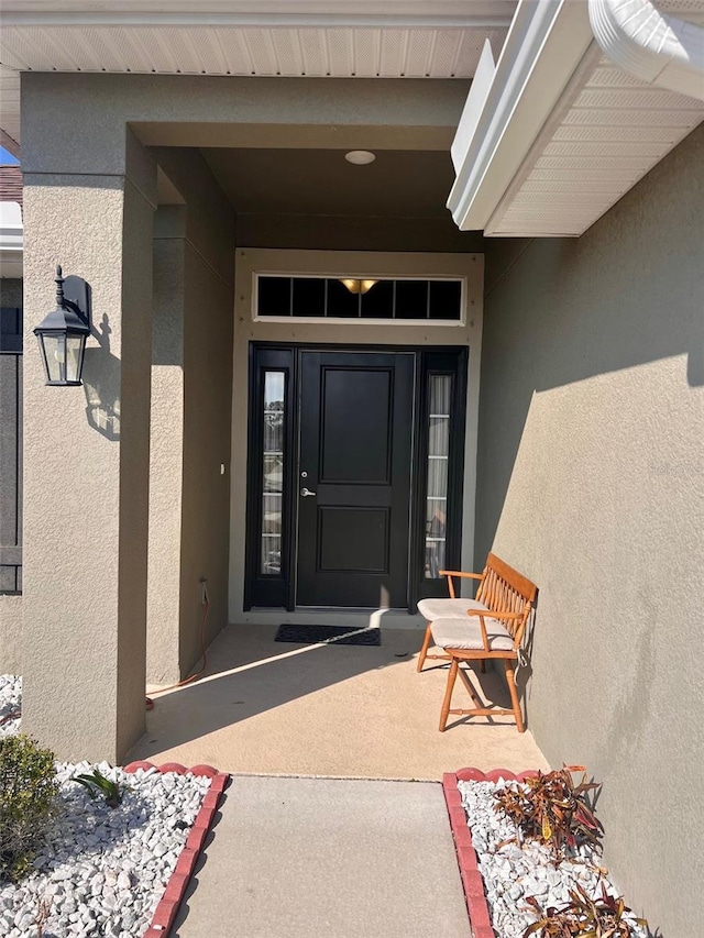 entrance to property with stucco siding