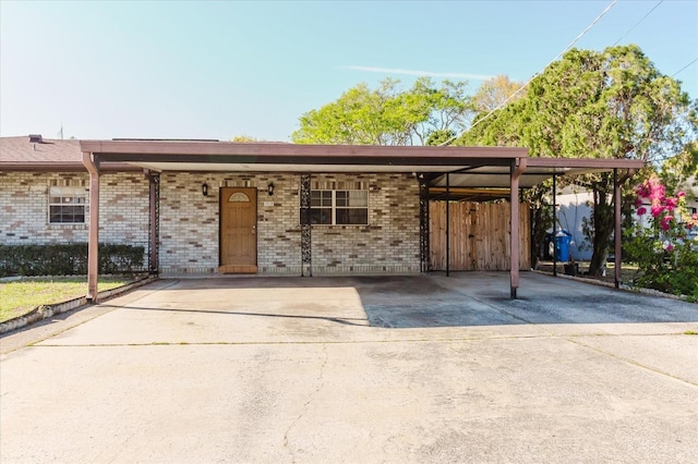 view of front facade with driveway, an attached carport, and brick siding