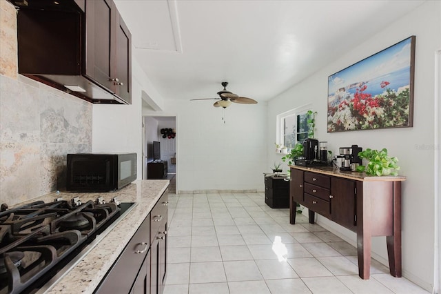 kitchen with light stone counters, light tile patterned floors, a ceiling fan, dark brown cabinets, and black appliances