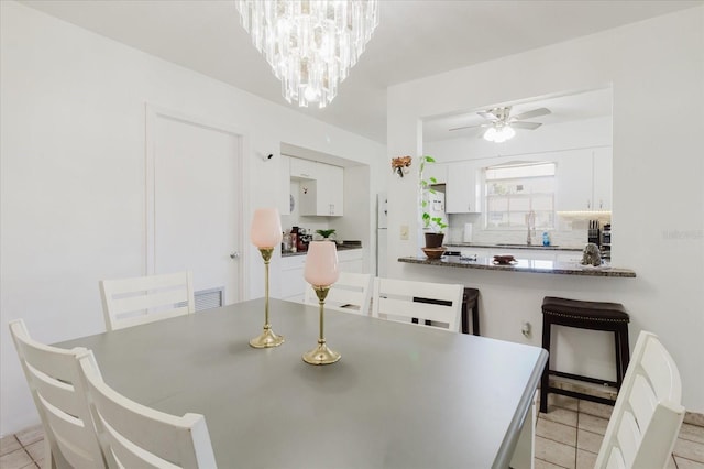 dining space with light tile patterned flooring, visible vents, and ceiling fan with notable chandelier