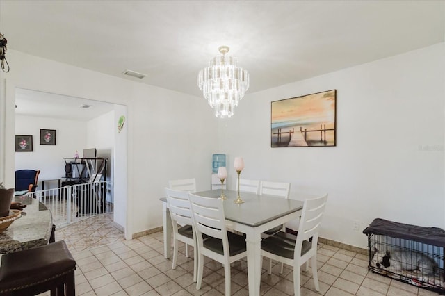 dining space featuring a chandelier, light tile patterned floors, visible vents, and baseboards