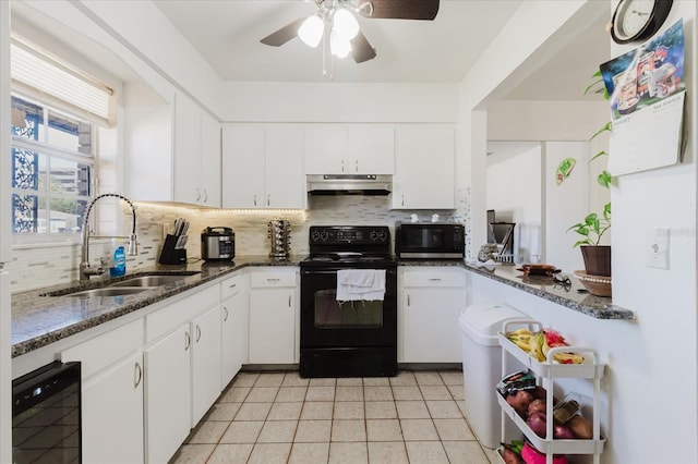 kitchen featuring under cabinet range hood, a sink, white cabinetry, black appliances, and tasteful backsplash