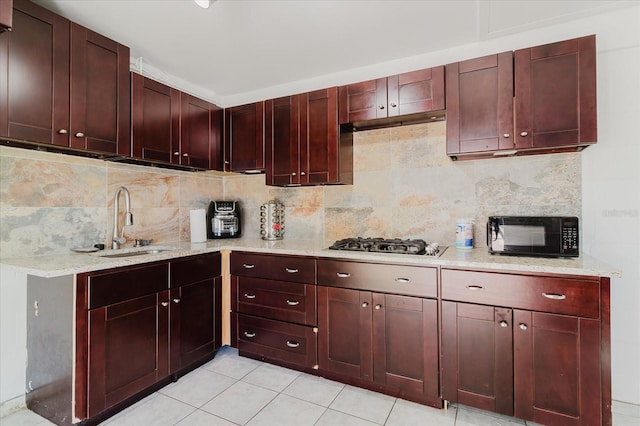 kitchen featuring black microwave, a sink, stainless steel gas cooktop, and dark brown cabinets