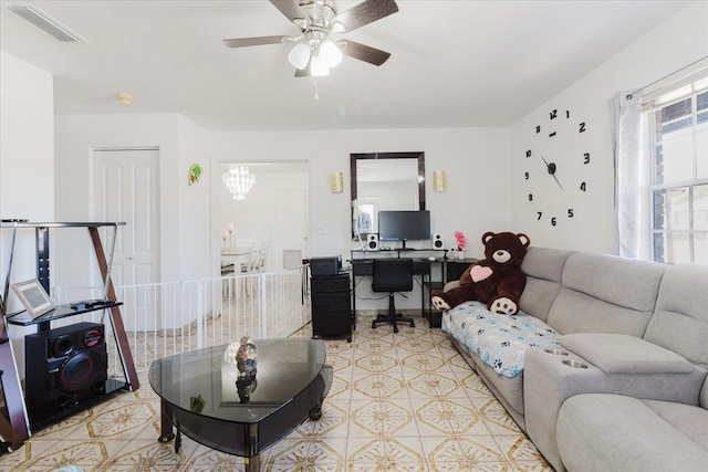 living area with ceiling fan with notable chandelier and visible vents