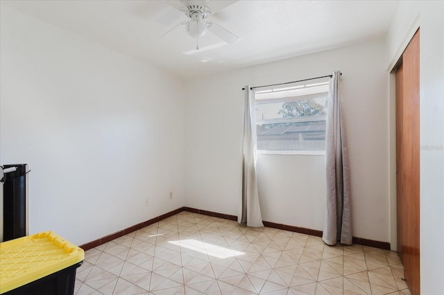 unfurnished room featuring light tile patterned floors, baseboards, and a ceiling fan