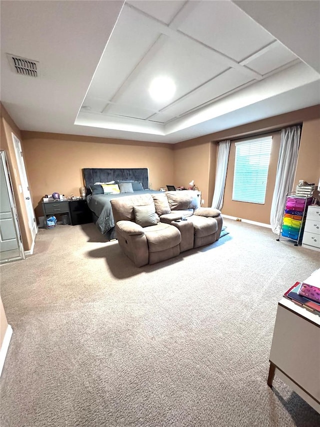 carpeted home theater room with visible vents, coffered ceiling, and a raised ceiling