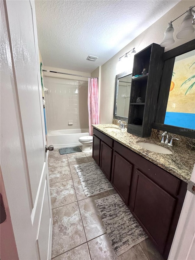 bathroom with shower / bath combo, a sink, a textured ceiling, and toilet