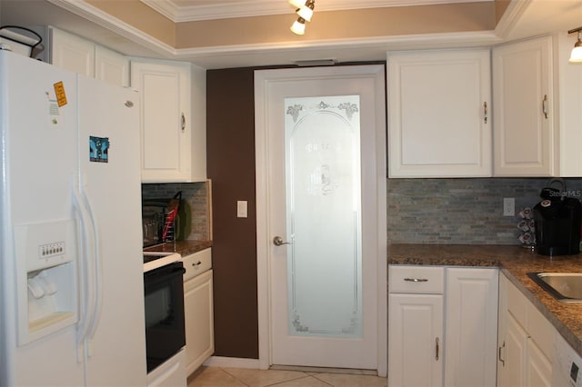 kitchen with white refrigerator with ice dispenser, range with electric stovetop, light tile patterned floors, ornamental molding, and white cabinetry