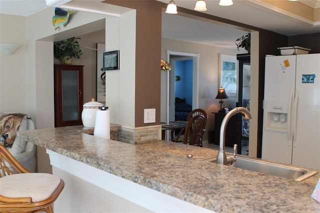 kitchen with white refrigerator with ice dispenser and a sink