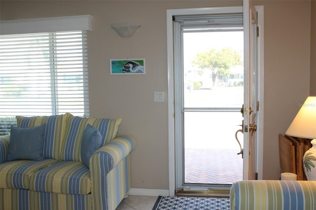 doorway with baseboards and light tile patterned floors