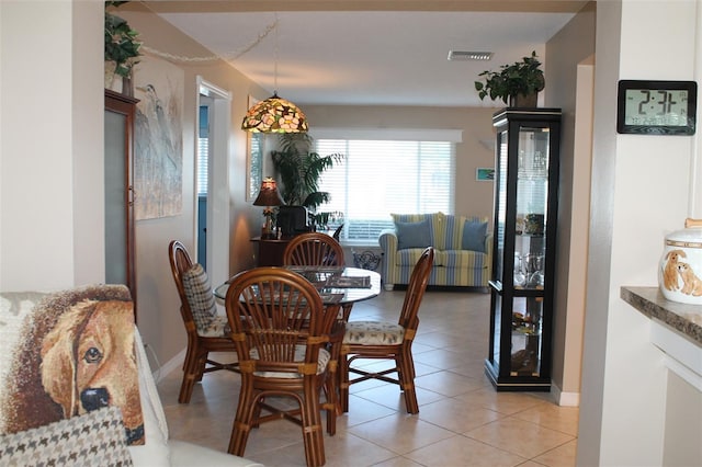 dining area featuring baseboards, visible vents, and light tile patterned flooring