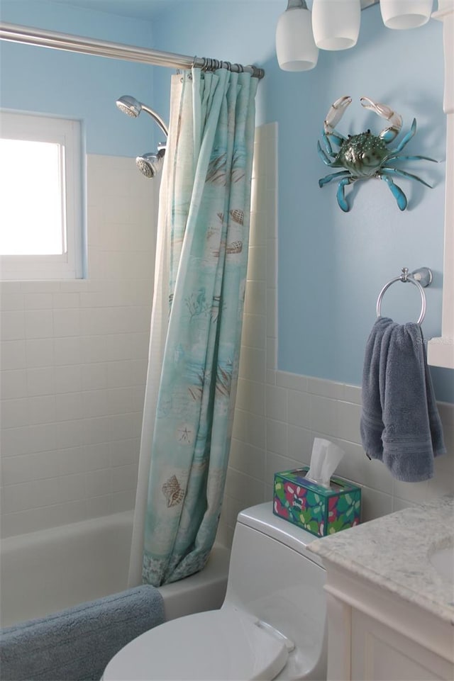 bathroom with shower / bath combo, tile walls, toilet, and vanity