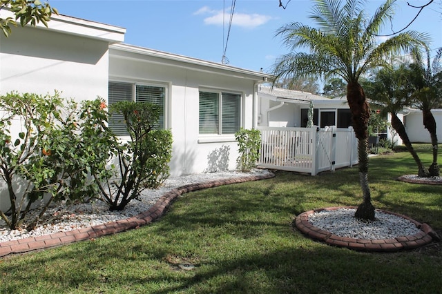 view of side of home featuring a lawn and stucco siding