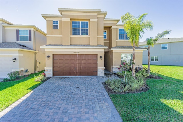 multi unit property featuring an attached garage, stone siding, decorative driveway, stucco siding, and a front lawn