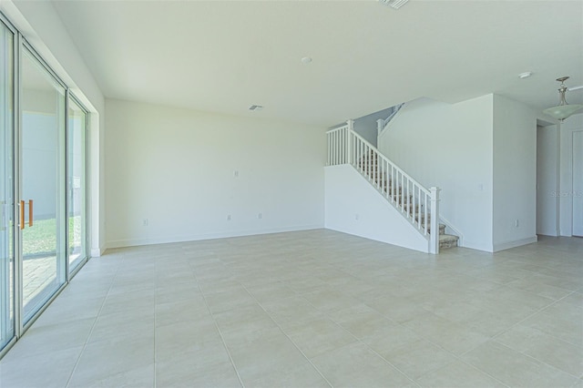 unfurnished room with stairs and baseboards