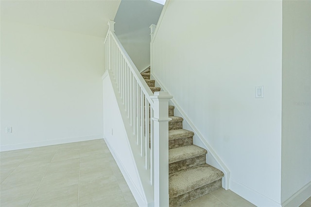 staircase featuring tile patterned flooring and baseboards