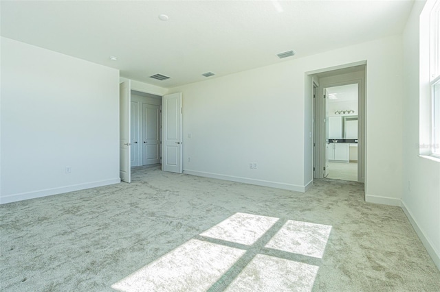 unfurnished bedroom with baseboards, visible vents, and light colored carpet