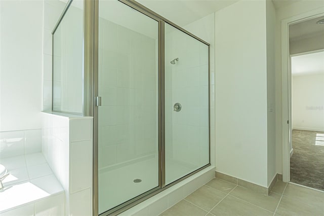 bathroom featuring a stall shower, baseboards, and tile patterned floors