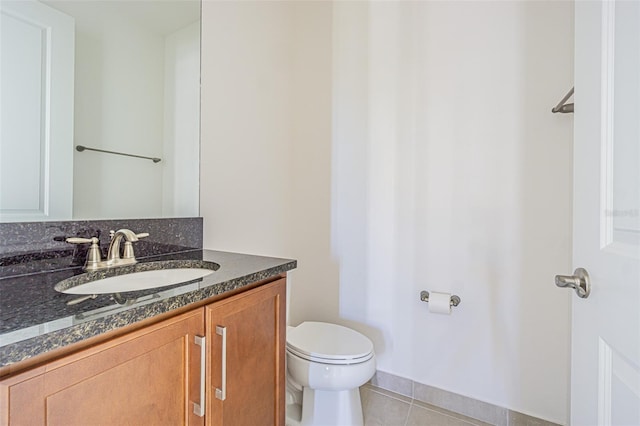 half bathroom featuring tile patterned flooring, vanity, and toilet