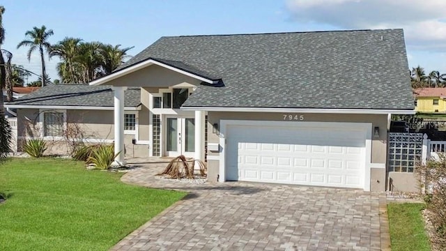 view of front facade featuring a garage, a shingled roof, decorative driveway, stucco siding, and a front lawn