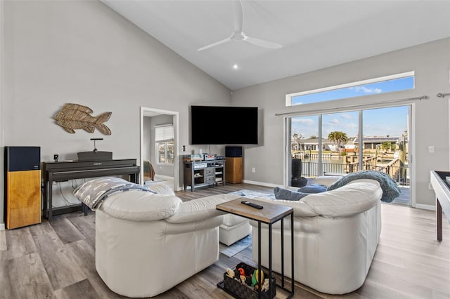 living room with light wood-type flooring, ceiling fan, and baseboards