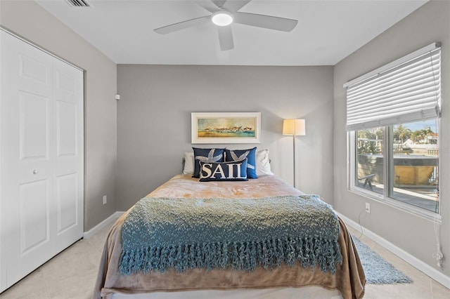 bedroom featuring light tile patterned floors, visible vents, a ceiling fan, and baseboards