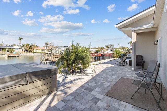 view of patio / terrace with a water view and a hot tub