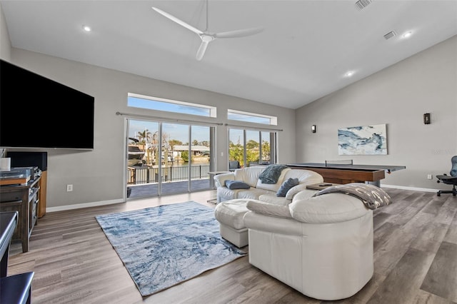 living room with high vaulted ceiling, wood finished floors, visible vents, and baseboards