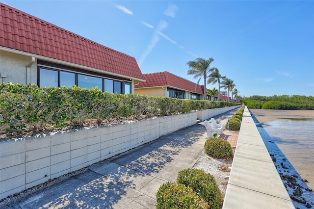 view of home's exterior featuring a tile roof and stucco siding