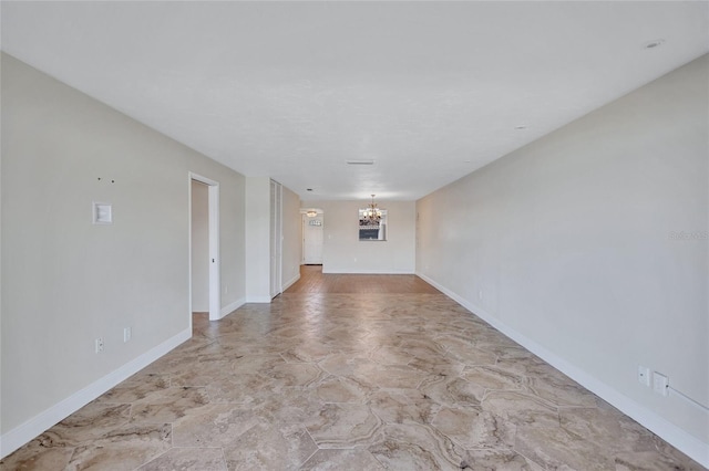 unfurnished room featuring baseboards and an inviting chandelier