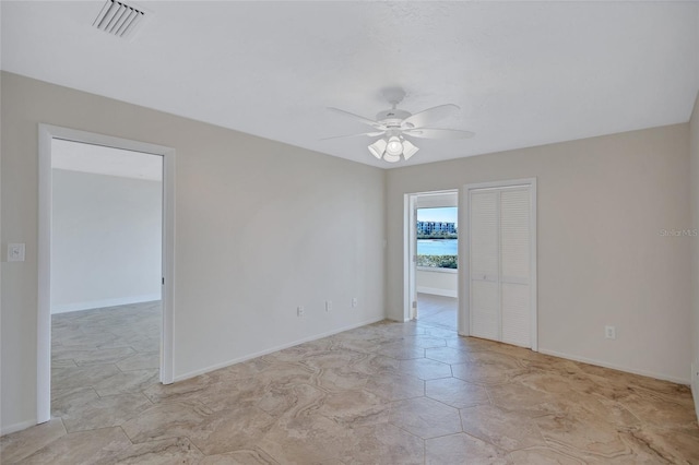 unfurnished room featuring baseboards, visible vents, and a ceiling fan