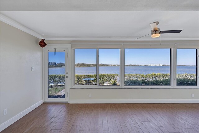 unfurnished sunroom featuring a water view, a ceiling fan, and a healthy amount of sunlight