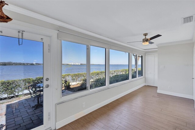 unfurnished sunroom with a water view, visible vents, and a ceiling fan