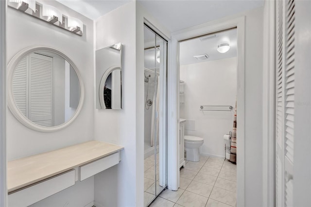 full bath featuring toilet, tile patterned flooring, walk in shower, vanity, and a closet