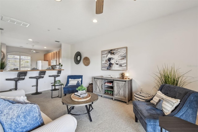living room featuring light carpet, ceiling fan, visible vents, and recessed lighting